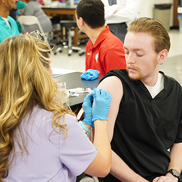 Student giving an immunization