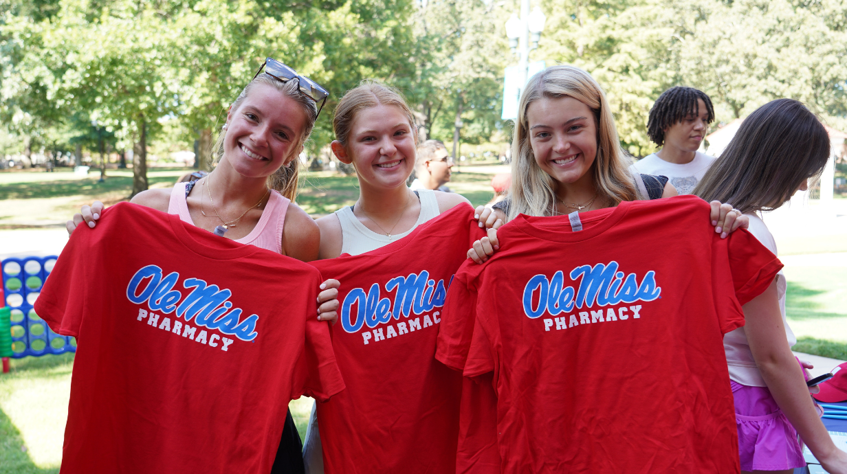 students holding up ole miss pharmacy tshirts