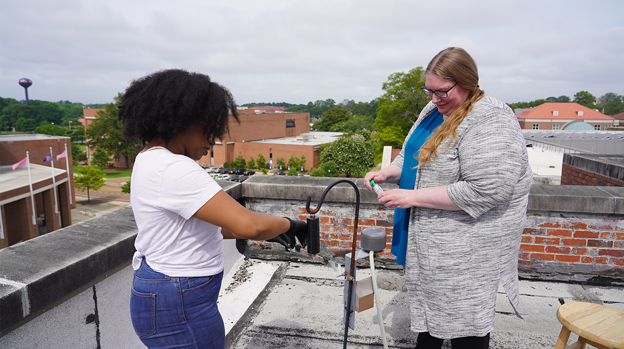 Dr. Roper working with student to collect air sample