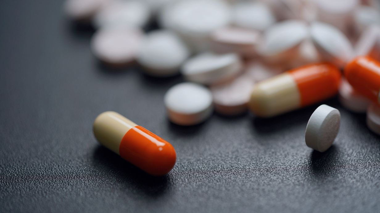 Photo of a capsule and tablet on a black table