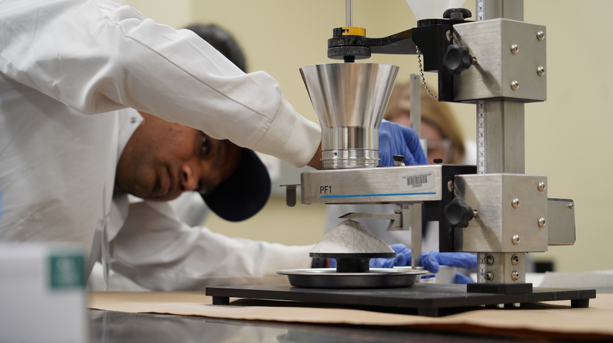 conference attendee measuring a cone of pharmaceutical materials
