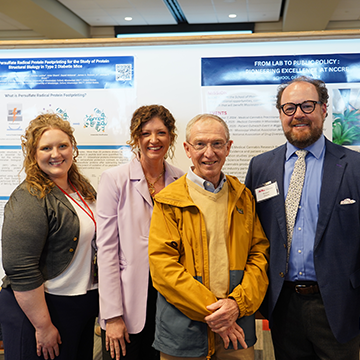 Cannabis Team standing in front of their poster.