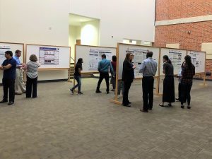 Multiple people looking at posters on bulletin boards