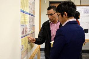Two men talking and looking at a research poster