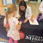 Lily Van works with a child at Mississippi Science Fest