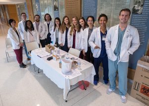 Group of student pharmacists standing behind a table