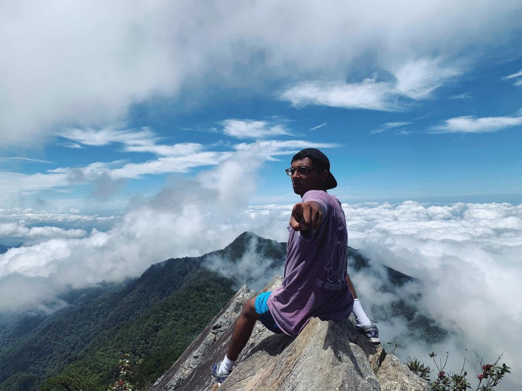 Sanjanwala sitting on top of mountain with clouds in the background