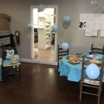 A room is decorated with blue decor for a baby shower.