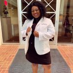 Alexcia stands and shows off her white coat