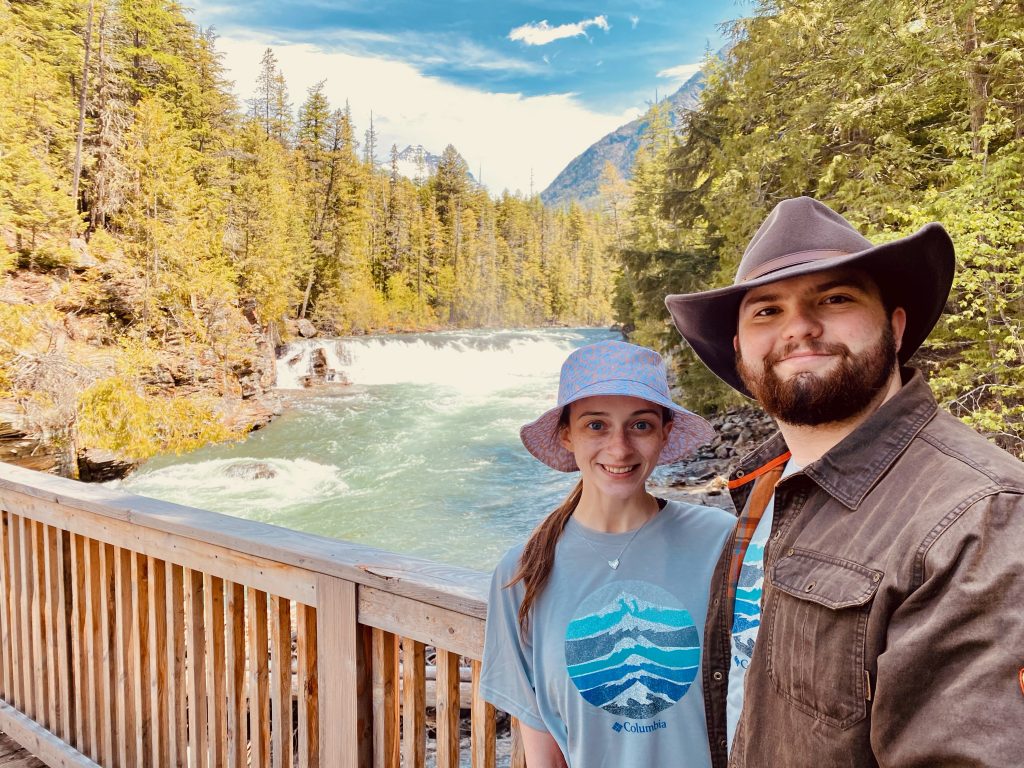 Leah Franks and husband standing on a bridge overlooking a river.