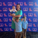 Mollie Spencer with her three kids in front of an Ole Miss Alumni Association backdrop