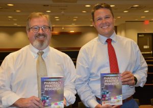 John Bentley and Adam Pate holding their new book