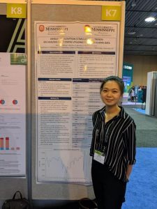 Zhang standing in front of research poster
