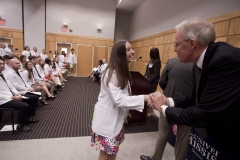 Students receive patch and shake hands with administrators